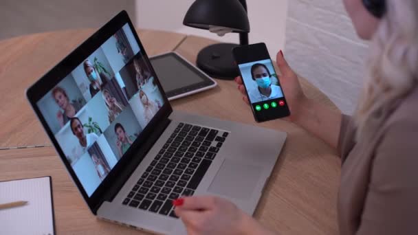 Žena má video chat s kolegy z notebooku v kanceláři, detailní záběr