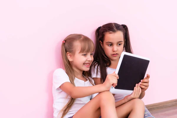 Dzieci, technologia i koncepcja domu - dwie dziewczynki z tabletem na podłodze w domu — Zdjęcie stockowe