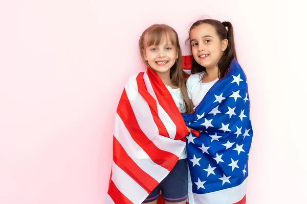 Niñas niños asombrados mostrando camiseta blanca, aislado sobre fondo rosa. Concepto de estilo de vida infantil. Prepara espacio para copias. Señalar el dedo índice a un lado —  Fotos de Stock