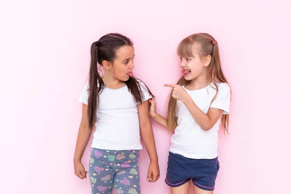 Dos chicas peleando por un fondo rosa — Foto de Stock
