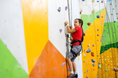 Beden dersinde duvara tırmanan küçük kız.