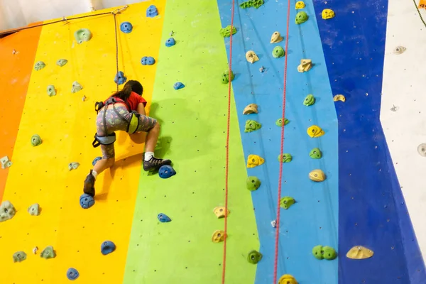 Pequeña niña escalada pared de roca pared práctica en el gimnasio —  Fotos de Stock