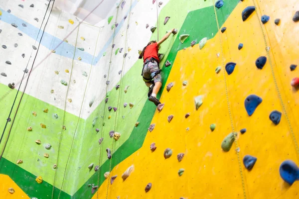 Liten flicka klättring Rock Wall praktisk vägg i gymmet — Stockfoto
