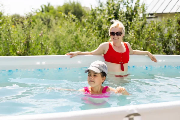 Mère et fille jouant ensemble dans la piscine à la maison — Photo