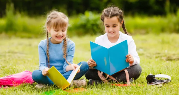 Ganska snygga skolflickor studerar online lektion på innergården, socialt avstånd under karantän, självisolering, online-utbildning koncept — Stockfoto