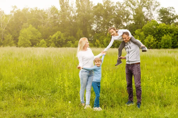 Família feliz desfrutando a vida juntos no prado ao ar livre. — Fotografia de Stock