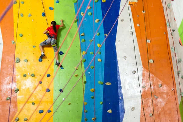 Menina escalada parede de rocha parede prática no ginásio — Fotografia de Stock