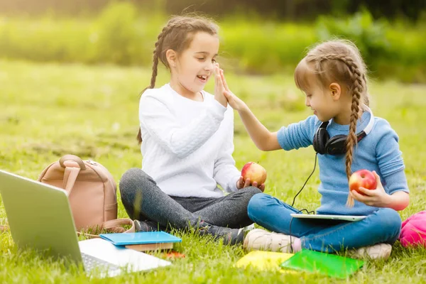 Cute schoolgirls eat outdoors. Healthy Lunches for schoolchildren. Lunch box with fruit. School lunch. — Stock Photo, Image