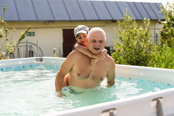 Portrait d'un grand-père heureux avec des petits-enfants dans la piscine — Photo