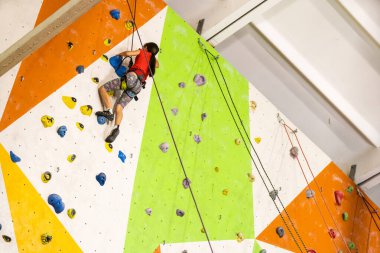 Küçük kız kaya duvarına tırmanıyor.