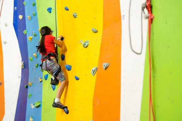 Klein meisje klimmen Rock Wall praktische muur in de sportschool — Stockfoto