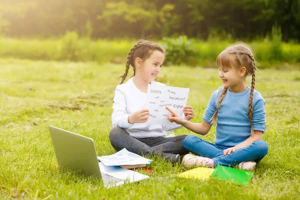 Studentesse piuttosto alla moda che studiano lezione online nel cortile, distanza sociale durante la quarantena, auto-isolamento, concetto di educazione online — Foto Stock