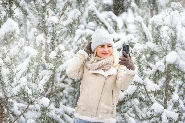 Junge lachende fröhliche Kaukasierin und Kiefernzweige im Winterwald. Positive Emotionen, Wandern bei verschneitem Wetter — Stockfoto