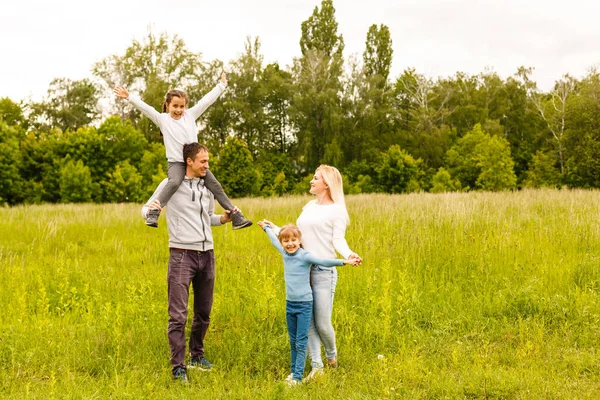 Счастливая семья, наслаждающаяся совместной жизнью на открытом воздухе meadow. — стоковое фото