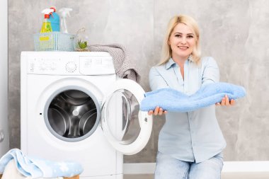 Çamaşırhanede gülümseyen güzel kız.