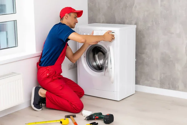Samec dospělý opravář s nástrojem a schránkou kontrolu pračky v koupelně — Stock fotografie