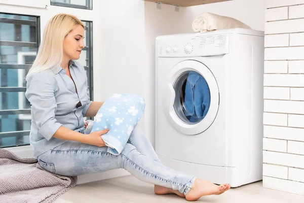 Una joven ama de casa con lavadora y ropa. Día de lavado. — Foto de Stock