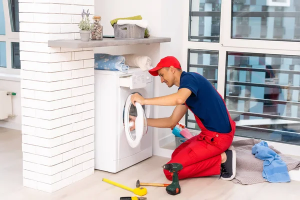 Samec dospělý opravář s nástrojem a schránkou kontrolu pračky v koupelně — Stock fotografie