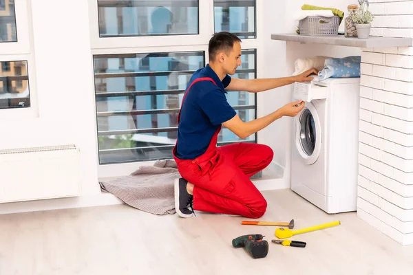 浴室配备工具和剪贴板检查洗衣机的男性成人修理工 — 图库照片