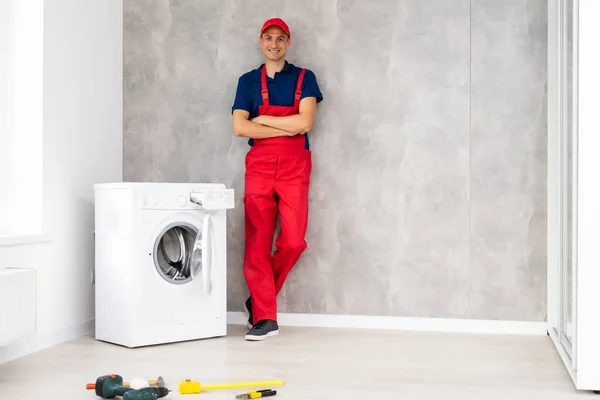 Man vuxen reparatör med verktyg och Urklipp kontroll tvättmaskin i badrummet — Stockfoto
