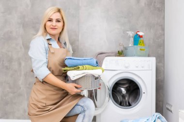 Çamaşırhanede gülümseyen güzel kız.