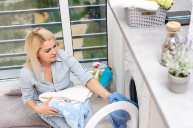 Çamaşırhanede gülümseyen güzel kız.