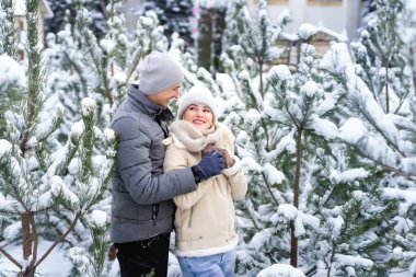 Karlı kış ormanlarında yürüyen, Noel tatilini birlikte geçiren mutlu bir çift. Açık havada mevsimlik aktiviteler. Yaşam biçimi