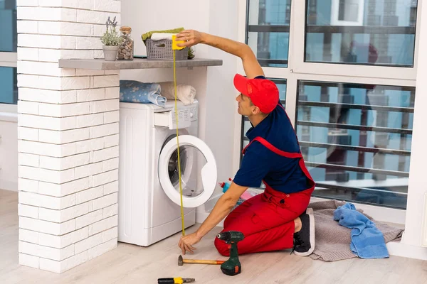 Male adult repairman with tool and clipboard checking washing machine in bathroom — Stock Photo, Image