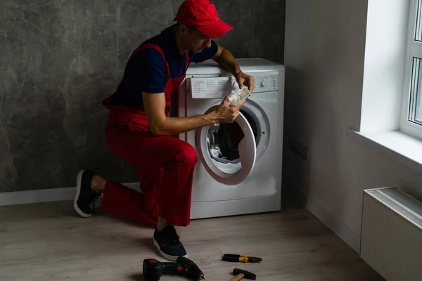 浴室配备工具和剪贴板检查洗衣机的男性成人修理工 — 图库照片