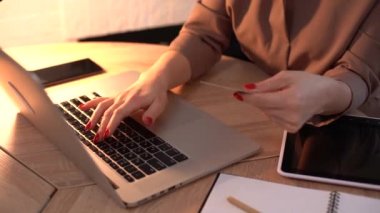 Bilgisayar klavyesinde kredi kartı numarası yazan kadın eller. İnternetten alışveriş yapan bir kadın. Çevrim içi ödeme servisi.