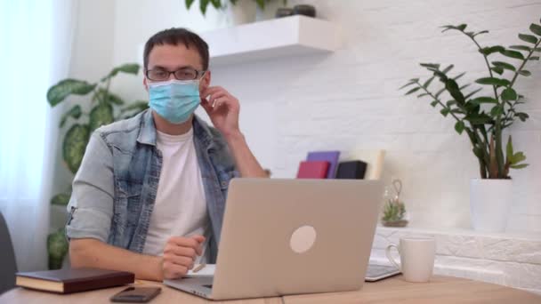 Ritratto di giovane uomo d'affari toglie maschera sul posto di lavoro. Lavoro sicuro in tempo pandemico — Video Stock