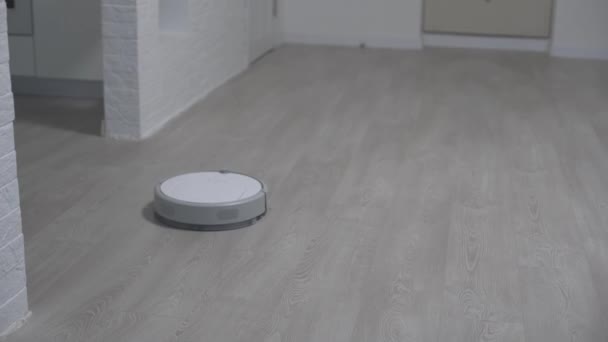 Robô aspirador de pó autumate, máquina de piso limpo. Robô de vácuo auto limpeza em casa. Aspirador robô realiza a limpeza automática do apartamento. Casa inteligente. — Vídeo de Stock