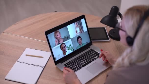 Mujer trabajando desde casa teniendo grupo videoconferencia en el ordenador portátil — Vídeos de Stock