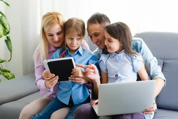 Famiglia felice di quattro genitori e bambini piccoli simpatici godono utilizzando il tablet, guardare cartoni animati, fare videochiamate su internet o fare shopping online guardando lo schermo del computer sedersi insieme a casa — Foto Stock