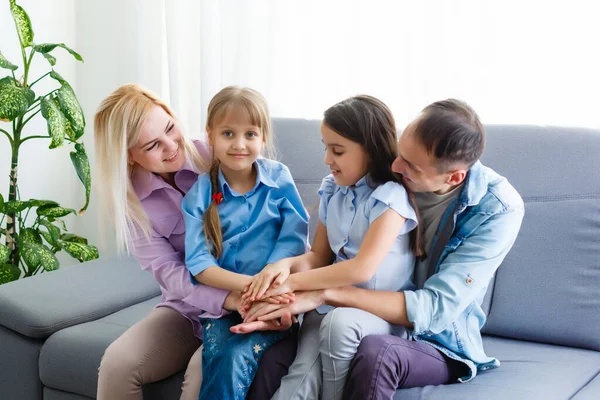 Giovane famiglia allegra con bambini che ridono seduti sul divano insieme, genitori con bambini che si divertono a casa — Foto Stock