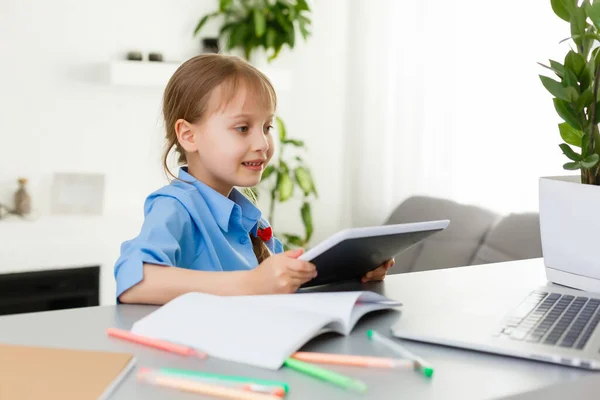 Távoli leckék. A gyermek boldogan mosolyog, és távolról kapja a tudást. Kislány tanul online tanulás otthonról. Online iskola. — Stock Fotó
