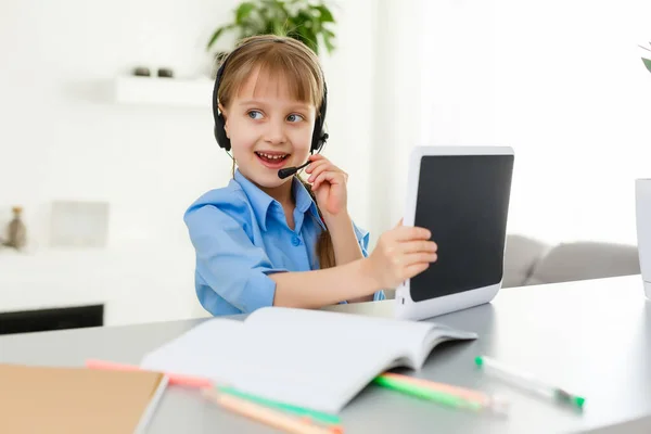 Des leçons à distance. L'enfant sourit joyeusement et obtient la connaissance à distance. Petite fille étudier l'apprentissage en ligne de la maison. École en ligne. — Photo