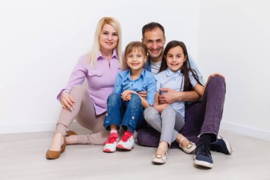 Evde gülümseyen mutlu bir ailenin portresi.