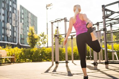 Spor salonundaki kadın mekik çekiyor. Güç antrenmanı yapıyor.