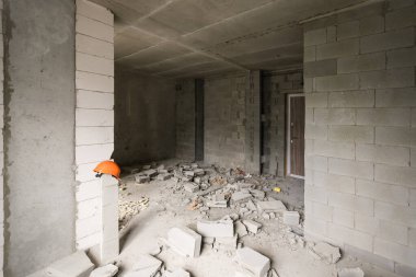 Tadilat için duvarı yıkın ve binanın girişi için kapıyı inşa edin. İnşaat alanında kırık tuğlalı el arabası..