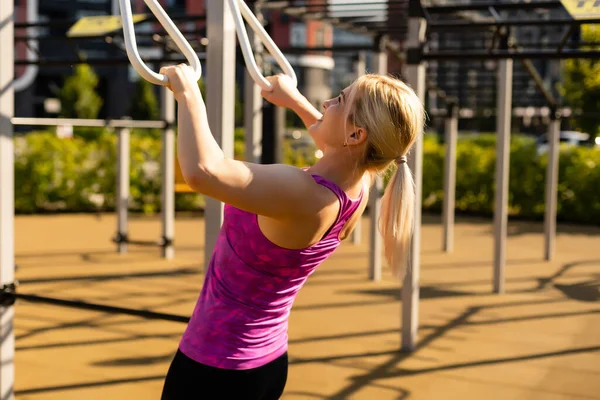 Mujer haciendo ejercicio en el gimnasio en el equipo al aire libre divertirse — Foto de Stock