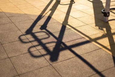 Açık hava fitness ekipmanının gölgesi. Eğimli sokak egzersiz makinesi spor sahasında. Atletizm eğitimi için ekipman. Güneşli bir gün, sert gölgeler.