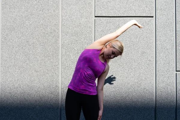 Mujer del deporte haciendo ejercicio de estiramiento durante el entrenamiento de entrenamiento cruzado al aire libre — Foto de Stock