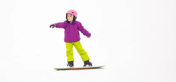在阳光明媚的冬日，小女孩在滑雪胜地滑雪板. — 图库照片