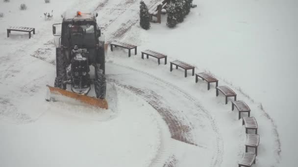 Tractor vehicle cleaning the yard from the snow storm — Stock Video