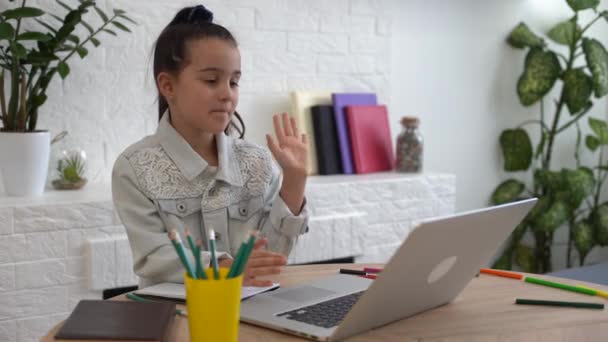 Nahaufnahme Foto von kleinen hübschen Schüler Schule sprechen Skype-Notizbuch Online-Unterricht Video-Anruf sitzen Schreibtisch, Entfernung, Klassenkameraden Quarantäne studieren Wohnzimmer drinnen — Stockvideo