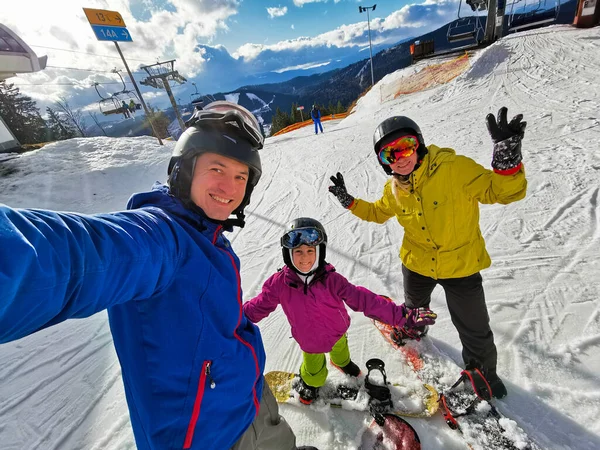 Snowboardosok családja téli üdülőhelyen a hegyekben — Stock Fotó