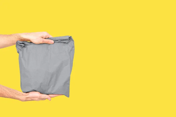 Pengiriman pria memegang tas kertas Trendy warna 2021 abu-abu dan kuning. — Stok Foto