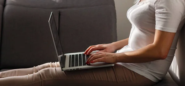 Kobieta korzystająca z laptopa podczas relaksu na kanapie — Zdjęcie stockowe