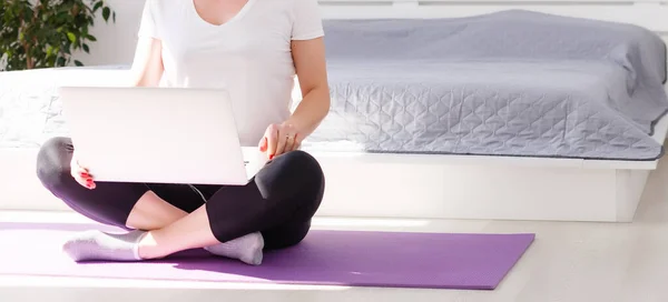 Hermosa mujer joven de formación en línea en casa en el ordenador portátil, espacio para copiar. Retrato de cuerpo entero. Yoga, pilates, hacer ejercicio — Foto de Stock